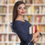 Woman with books smiling 1200x675 1